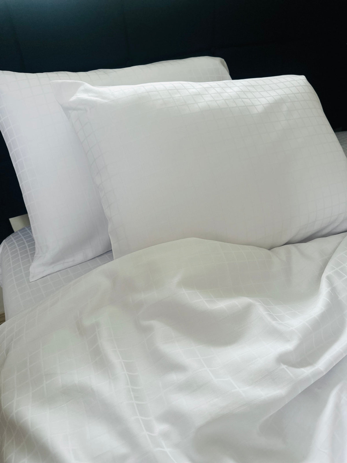 White jacquard sateen pillowcases on a bed with a dark headboard, ultra‑soft 100% Turkish cotton bedding
