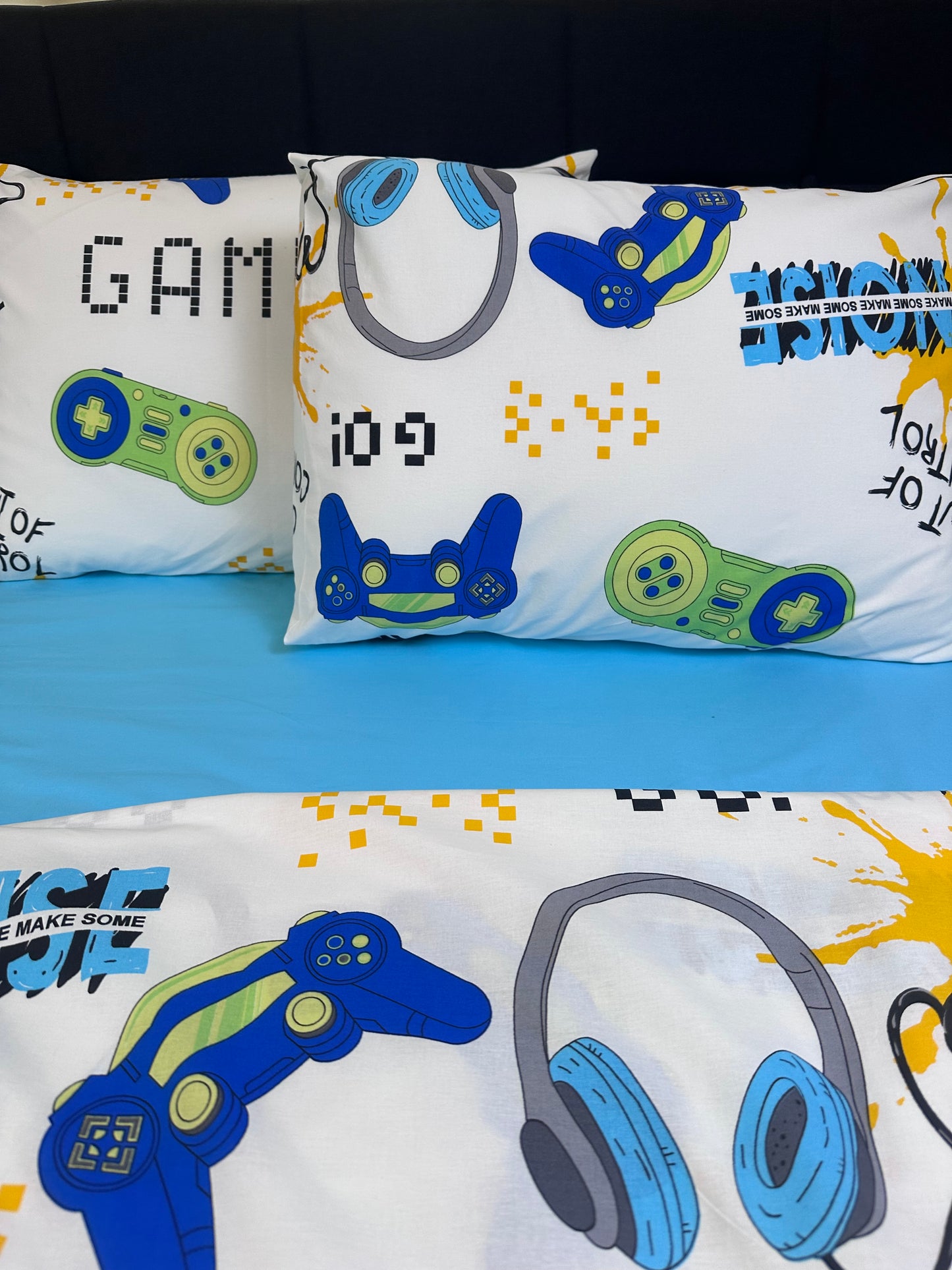 Two gamer kids pillowcases featuring controllers, headphones, and pixel text graphics as a fun decor accent in a boy's room