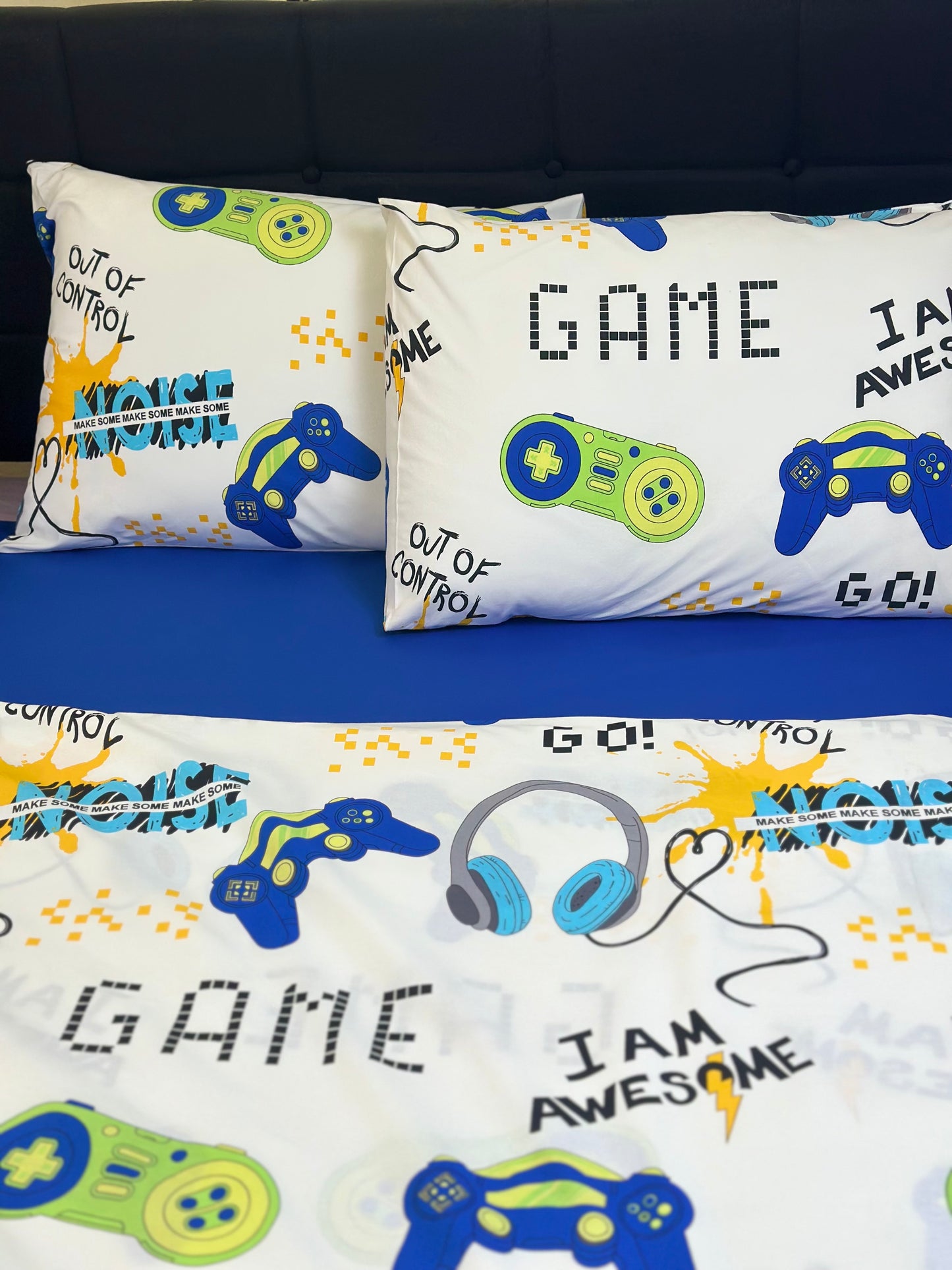 Toddler bed outfitted with an organic gamer kids bedding set, featuring a fun video game pattern