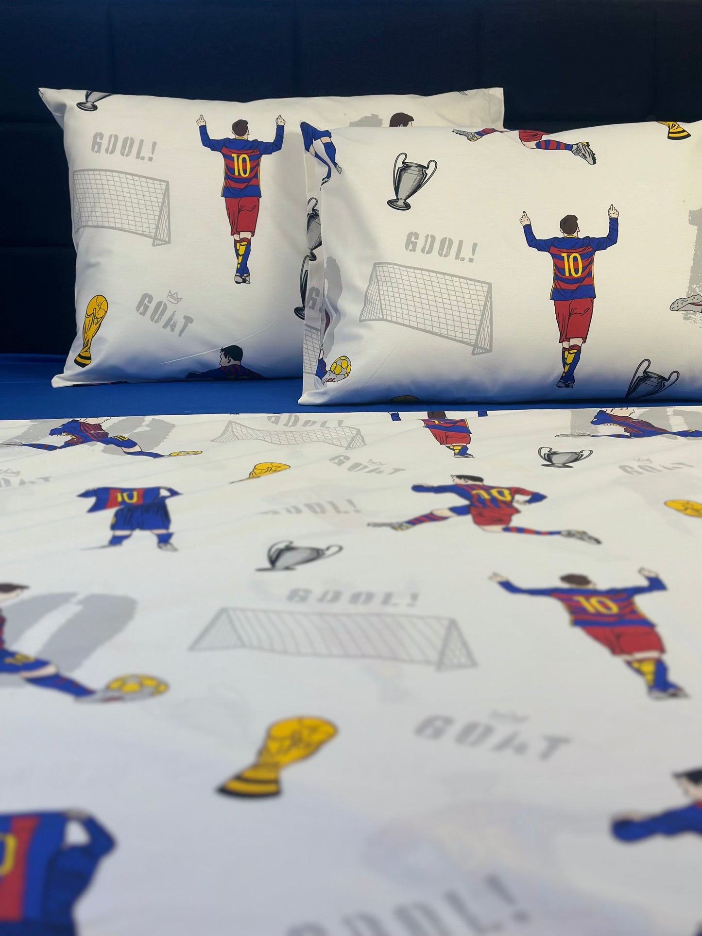 Pillowcases with sports-themed design featuring players and trophies on a blue background.