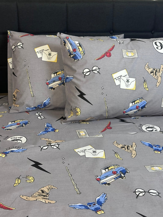 Magical organic cotton sheets featuring owls, letters, and wizard hats