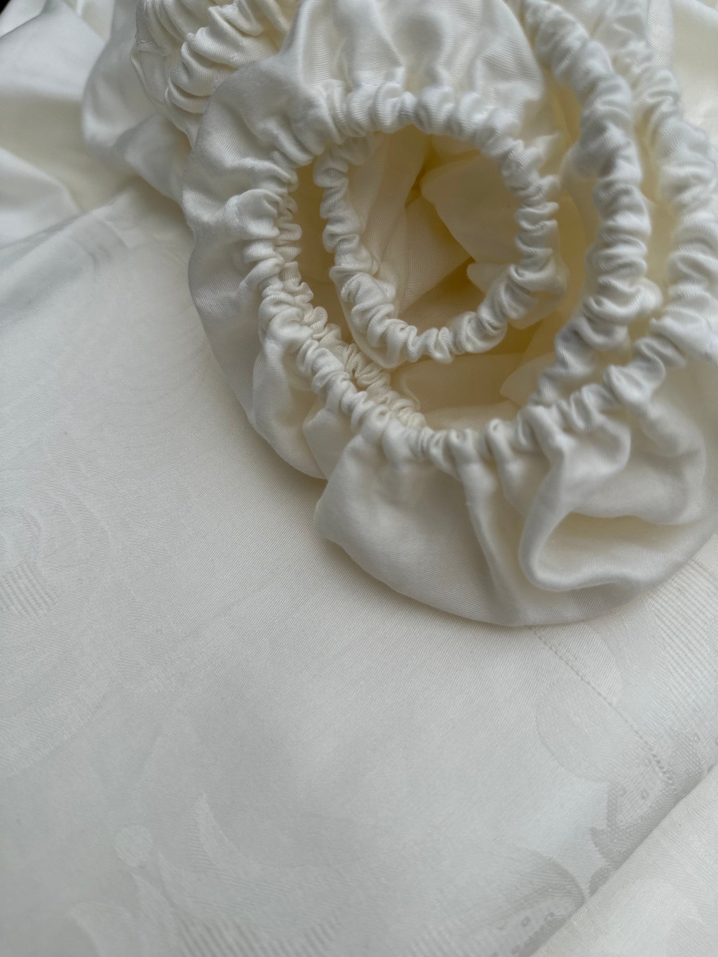 Folded organic sateen fitted sheet in soft beige color