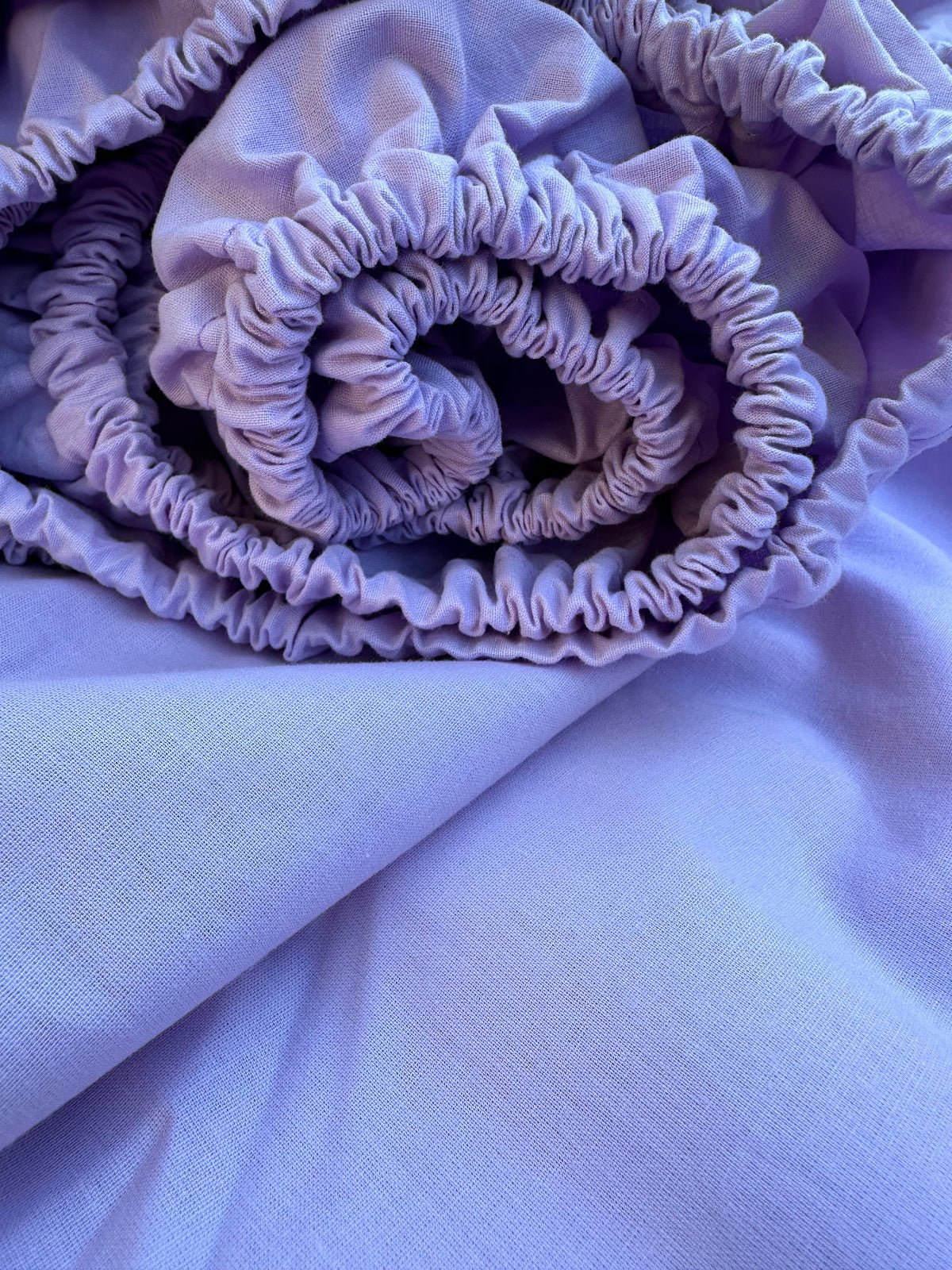Rolled lavender fitted sheet made from breathable natural Ranforse cotton with elastic edge – ideal for U.S., Canadian, Australian, and European beds.