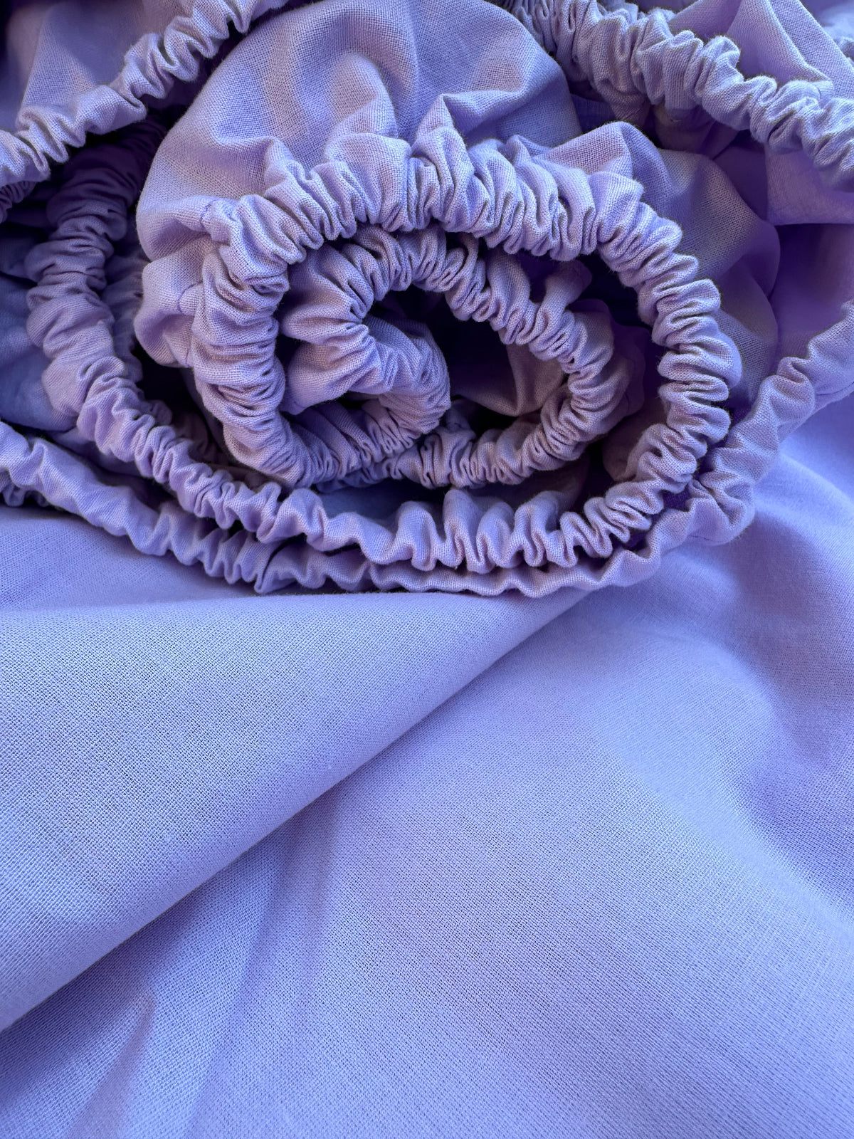 Rolled lavender fitted sheet made from breathable natural Ranforse cotton with elastic edge – ideal for U.S., Canadian, Australian, and European beds.