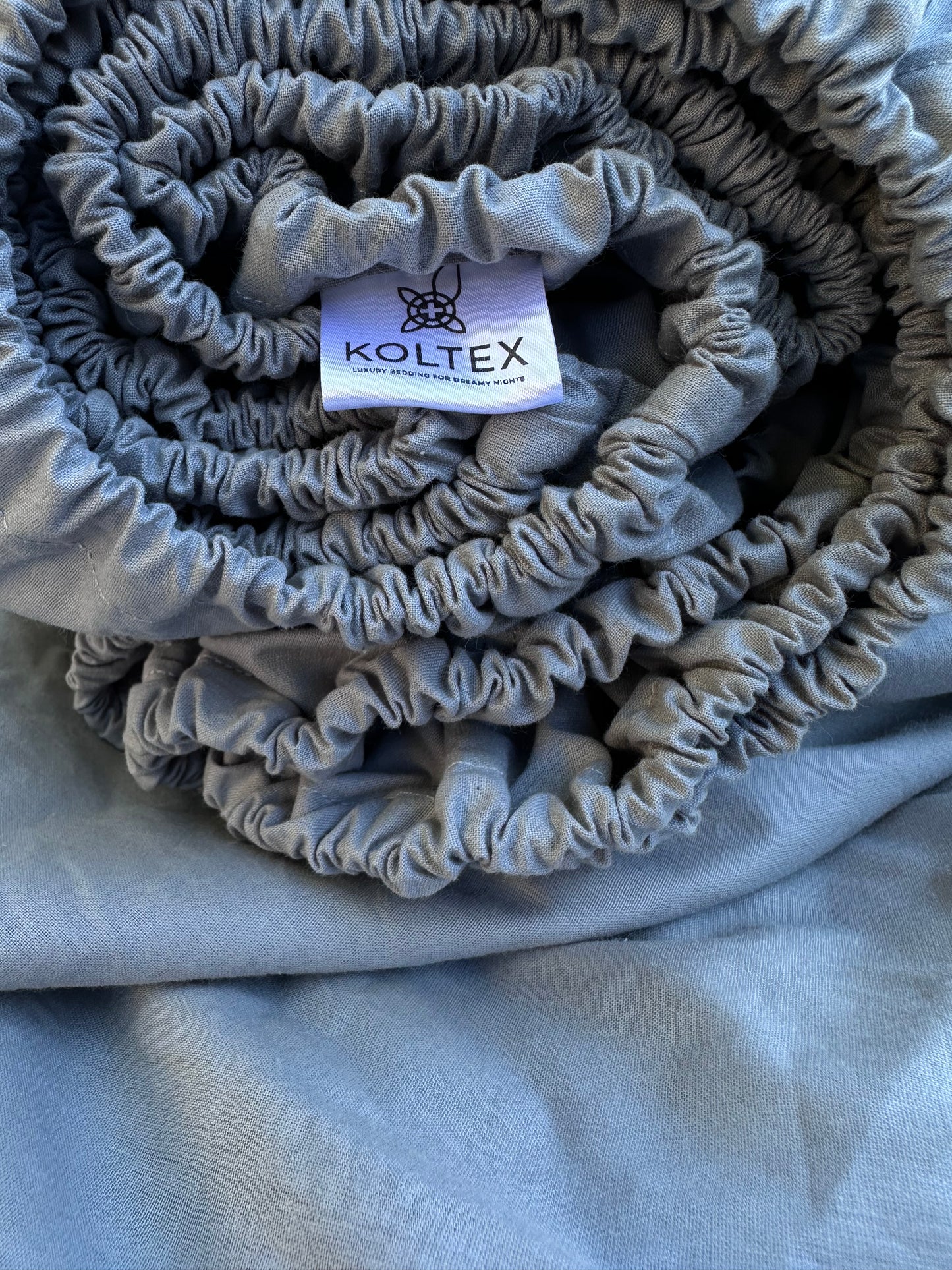 Rolled grey fitted sheet made from 100% natural Ranforse cotton with elastic edge – ideal for modern bedrooms in the U.S., Canada, Australia, and Europe.
