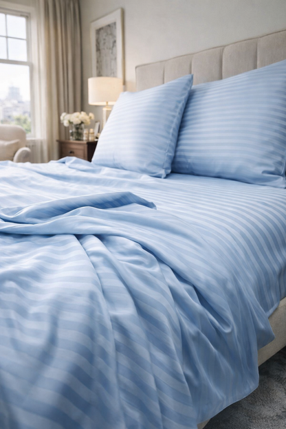 Close‑up of sky‑blue striped cotton bedding with smooth sateen texture