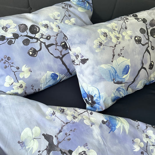 Bed styled with premium peacock-print floral pillowcases (100% cotton sateen).