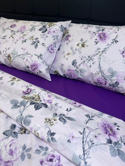 Purple rose print cotton bedding set with matching pillowcases on bed