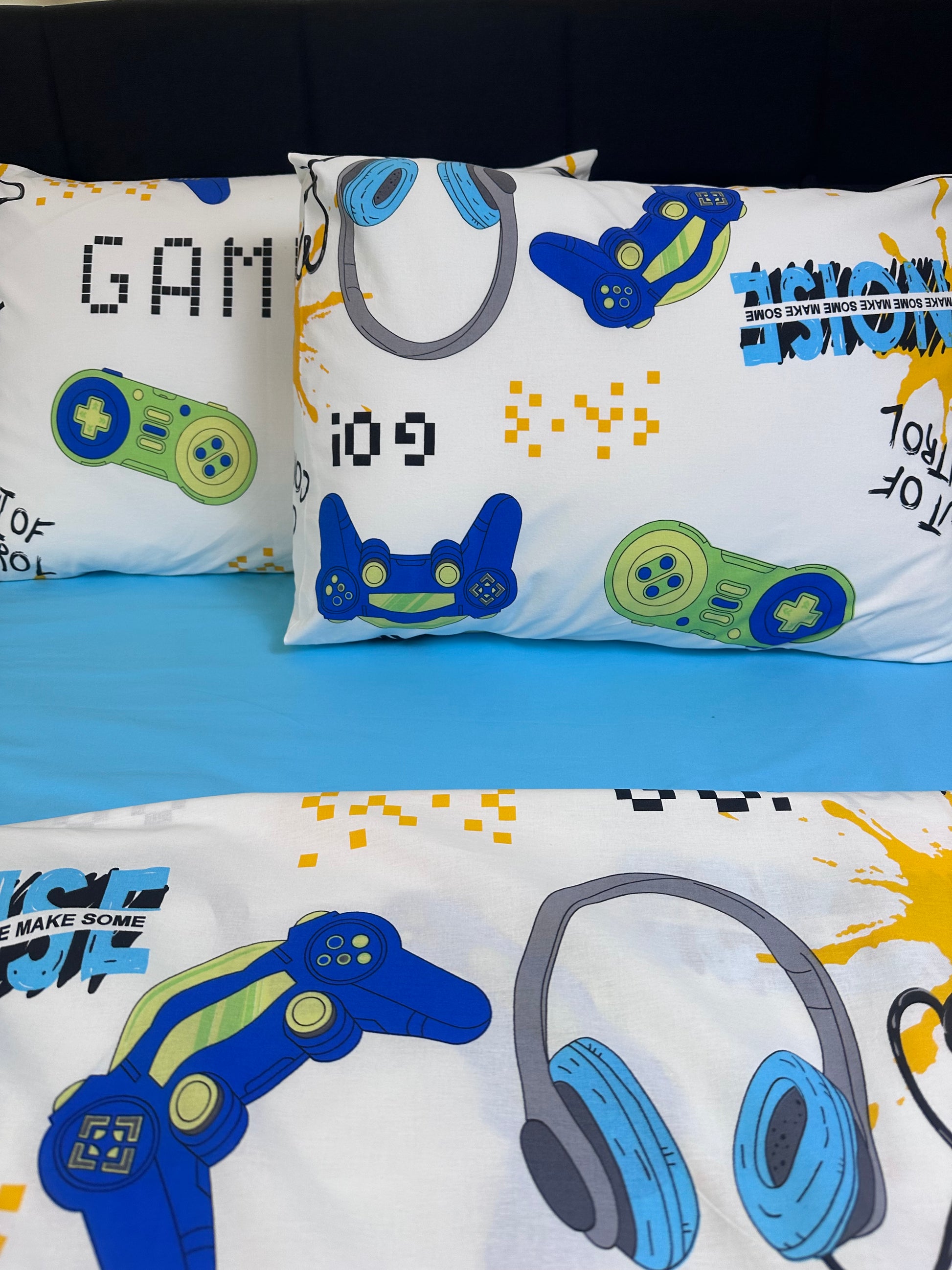 Two gamer kids pillowcases featuring controllers, headphones, and pixel text graphics as a fun decor accent in a boy's room