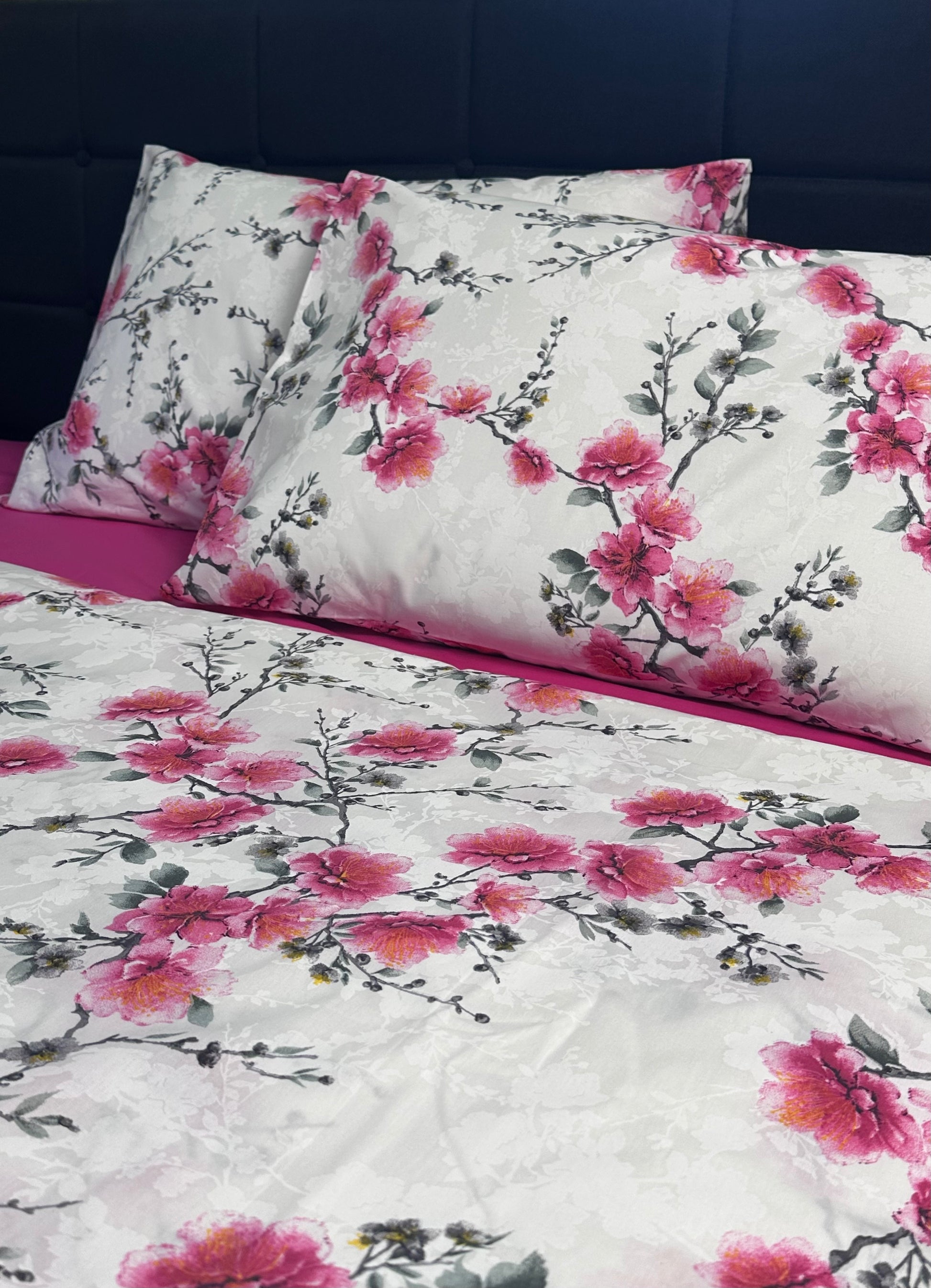 Close-up of cherry blossom pillows and pink sheet