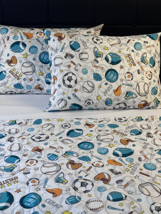 Children's sports-themed fabric with baseballs, soccer balls, and footballs on a white background.
