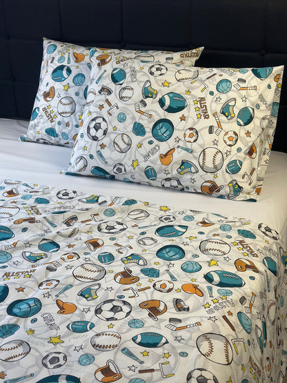 Children's sports-themed bedding set with pillows and sheet on a bed.