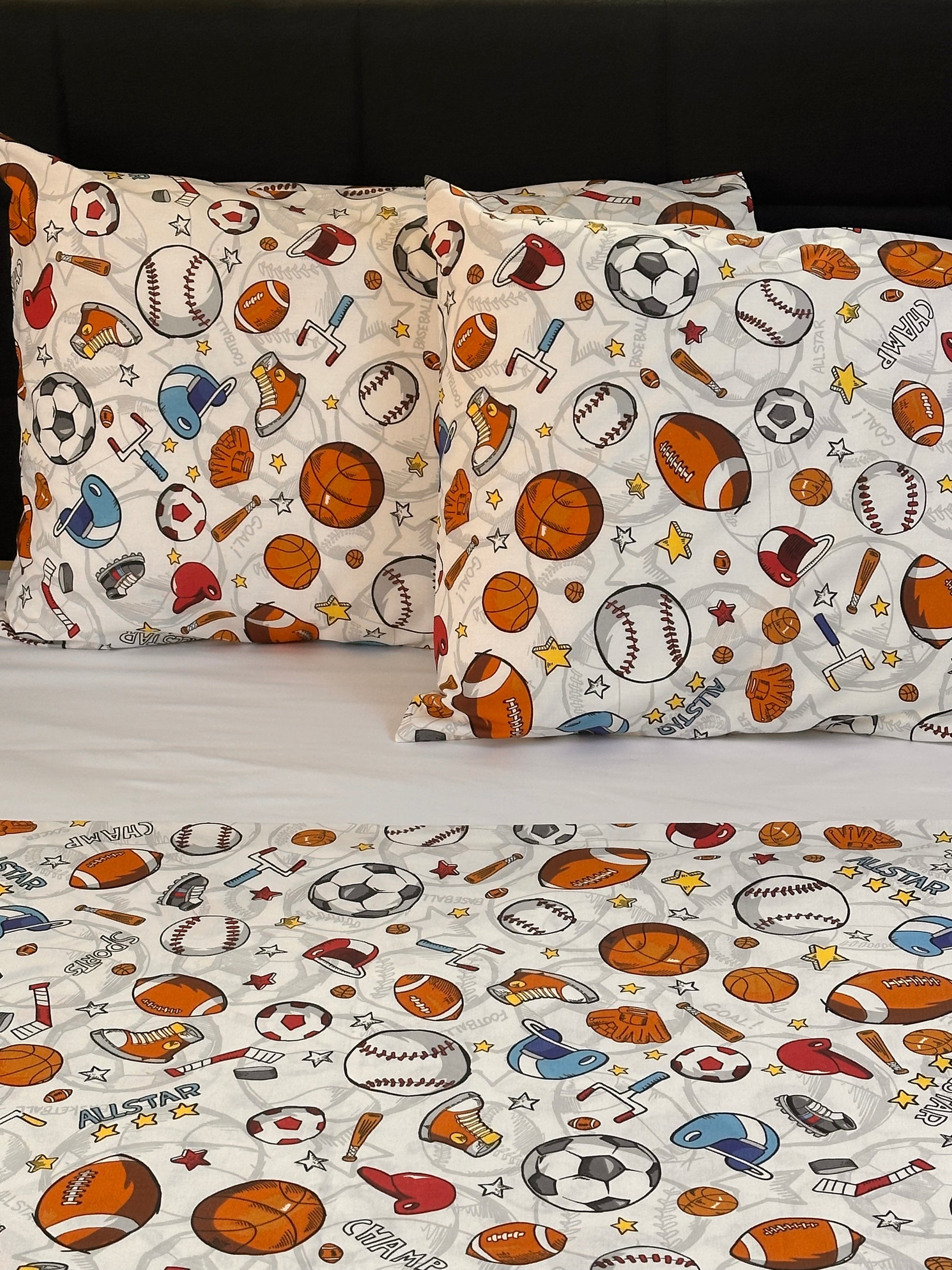 Fun boys bedroom white pillowcases with football, basketball, and hockey prints