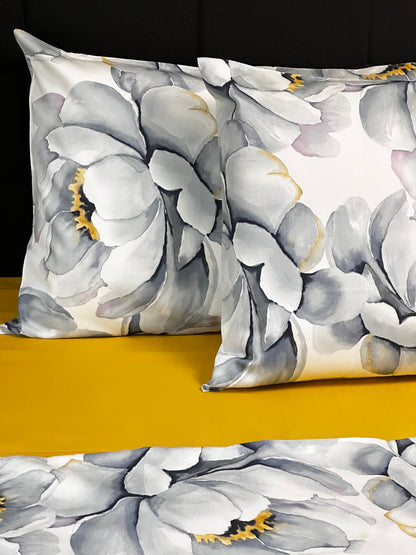Floral pillow with gray and white flowers on a yellow background
