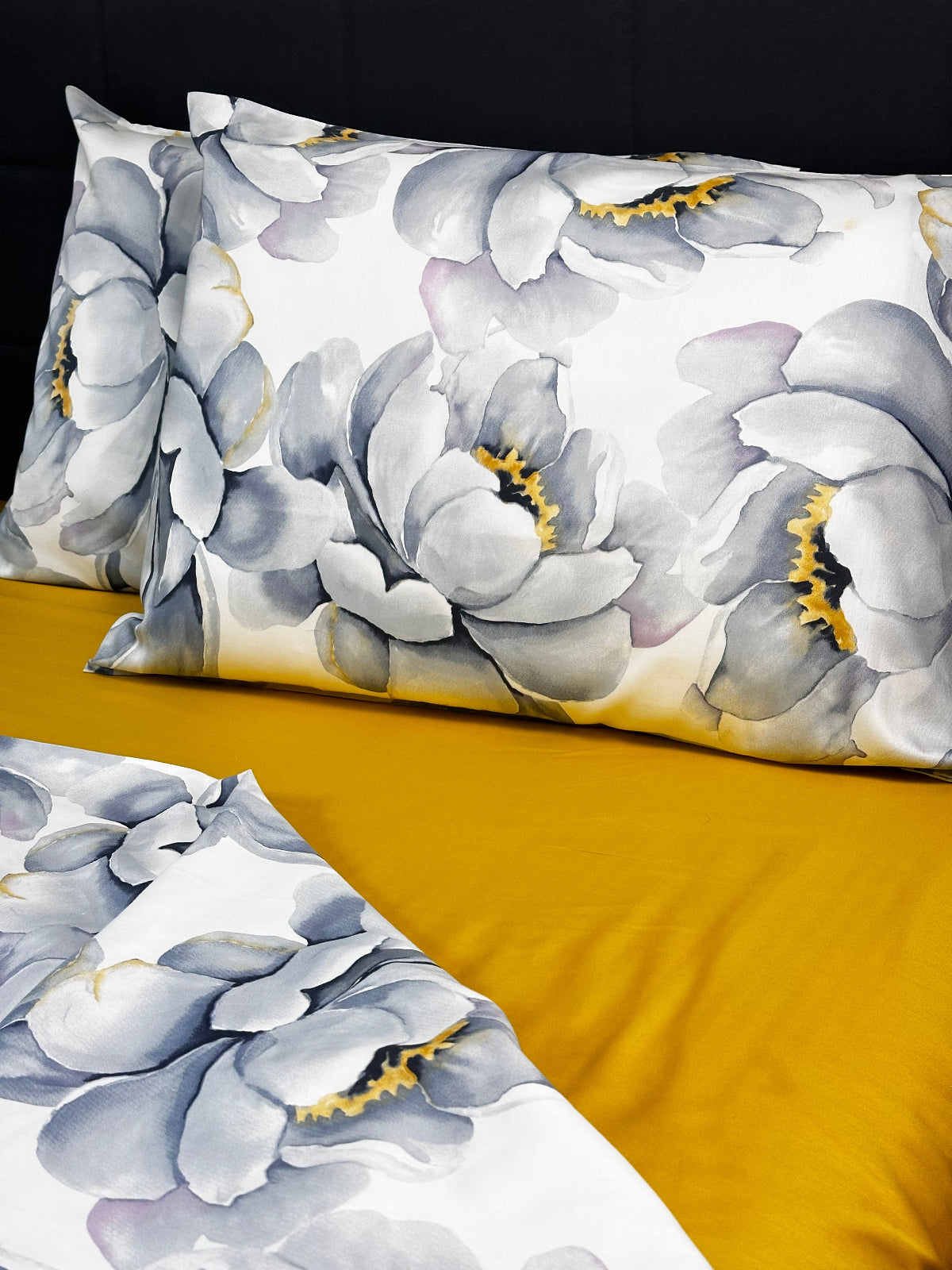 Floral-patterned fabric with gray flowers and yellow centers on a mustard background