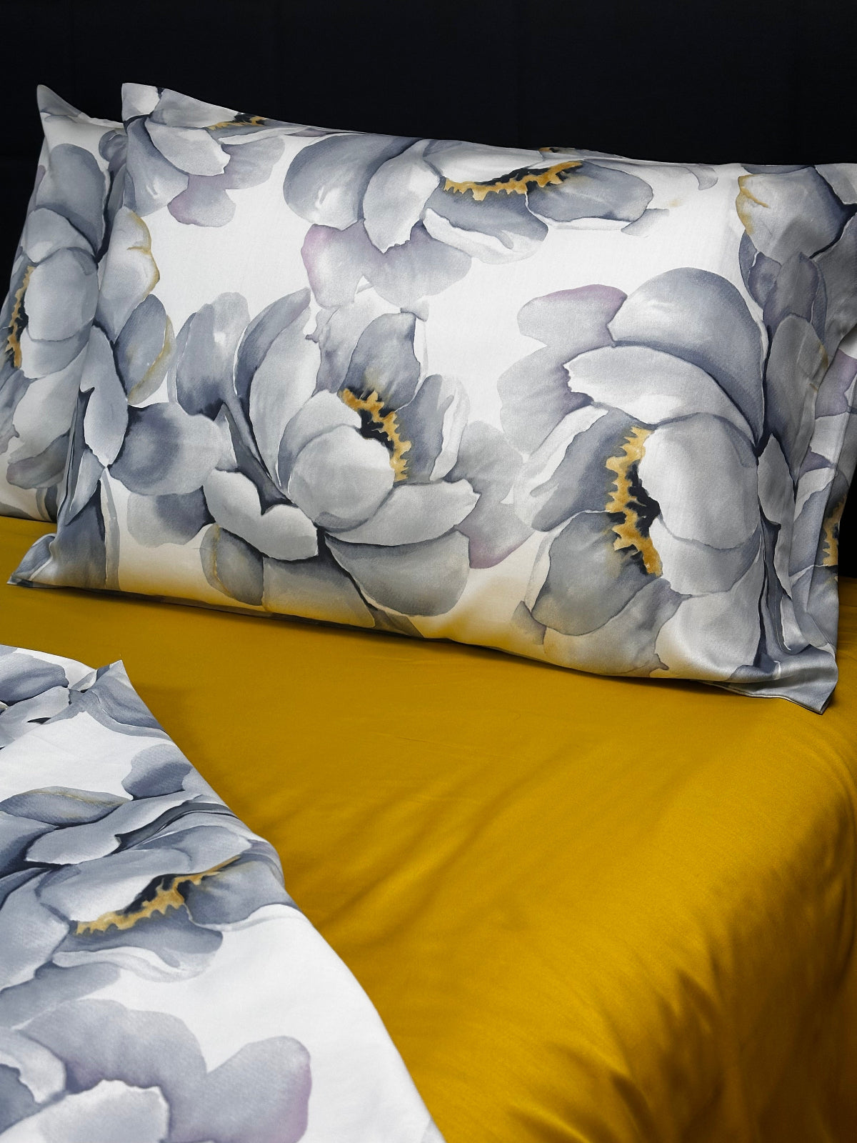 Floral-patterned pillow and blanket on a yellow surface