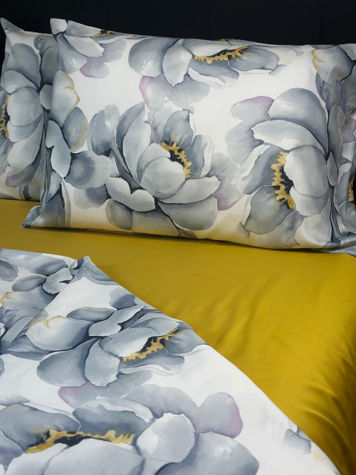 Luxury flower print bedding with big gray peonies and subtle yellow accents on white cotton fabric.