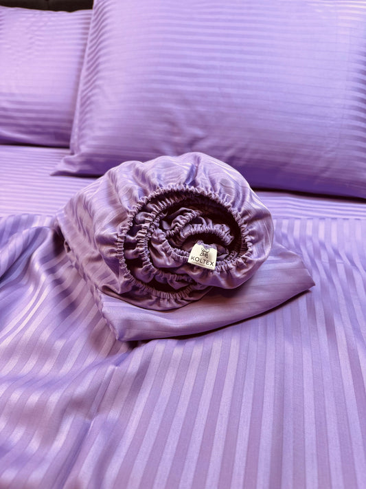 Lavender stripe sateen fitted sheet on a queen-size bed – silky Turkish cotton