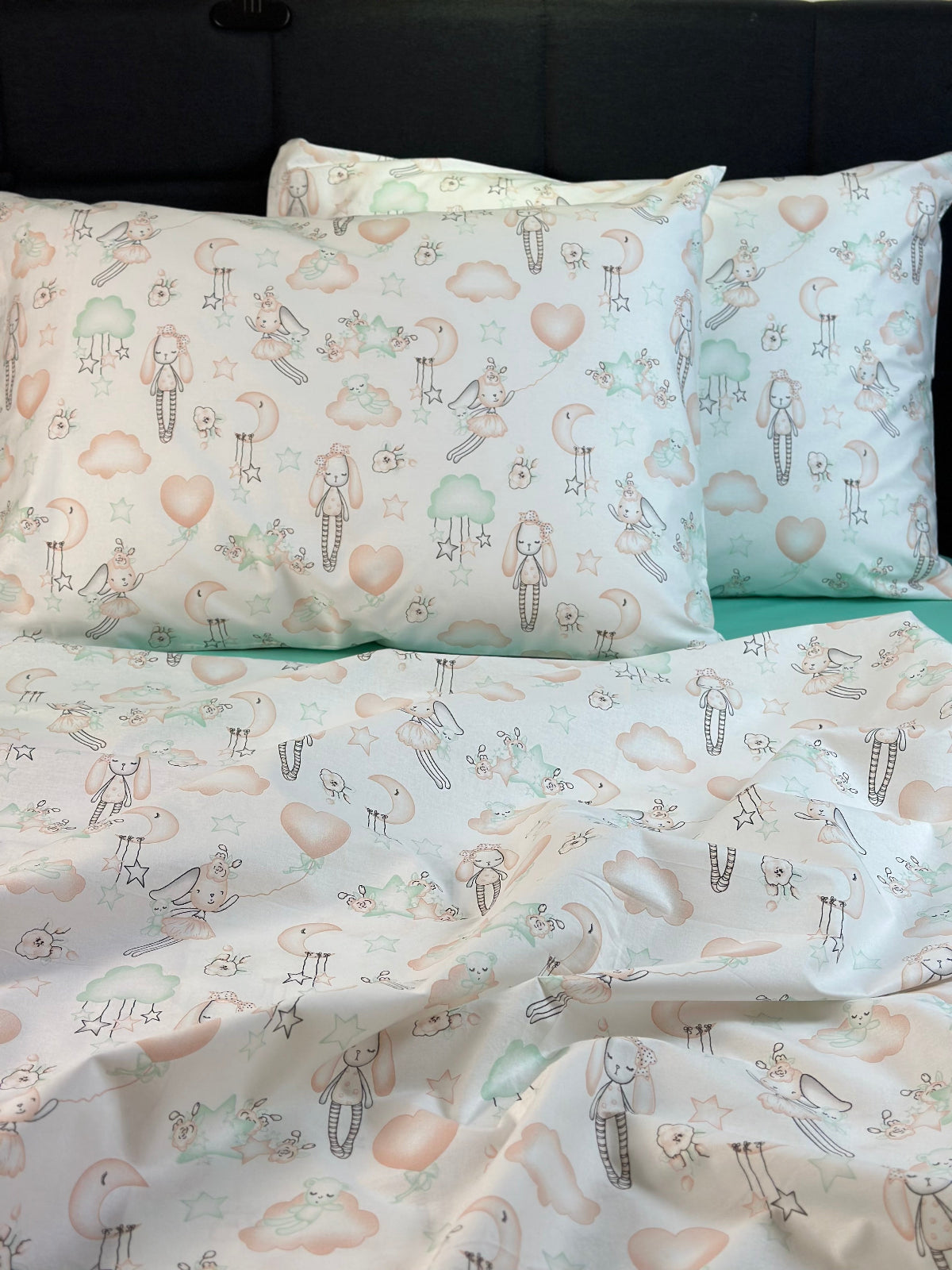 Children's bedding set with patterned pillowcases and duvet cover on a bed.