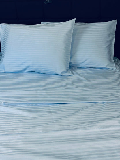 Soft sateen blue striped sheets and pillowcases folded neatly