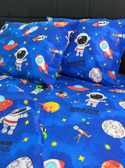 Blue children's bedding set with space-themed design featuring astronauts, rockets, and planets.