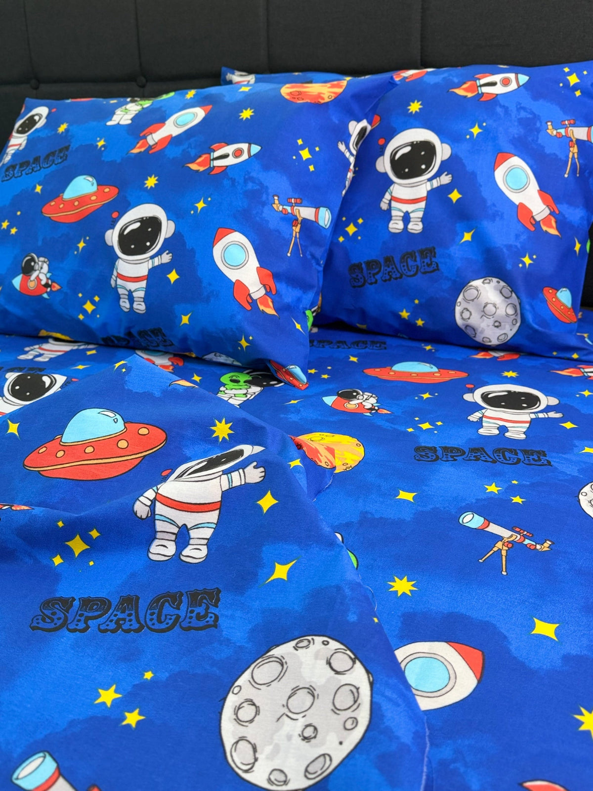 Space-themed bed sheet set with astronauts, rockets, and planets on a blue background.