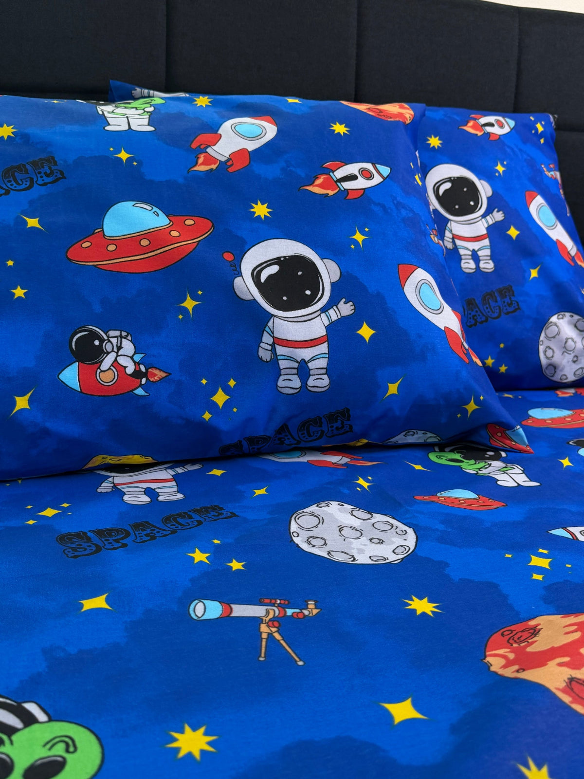 Blue fabric with space-themed patterns including astronauts, rockets, and planets.