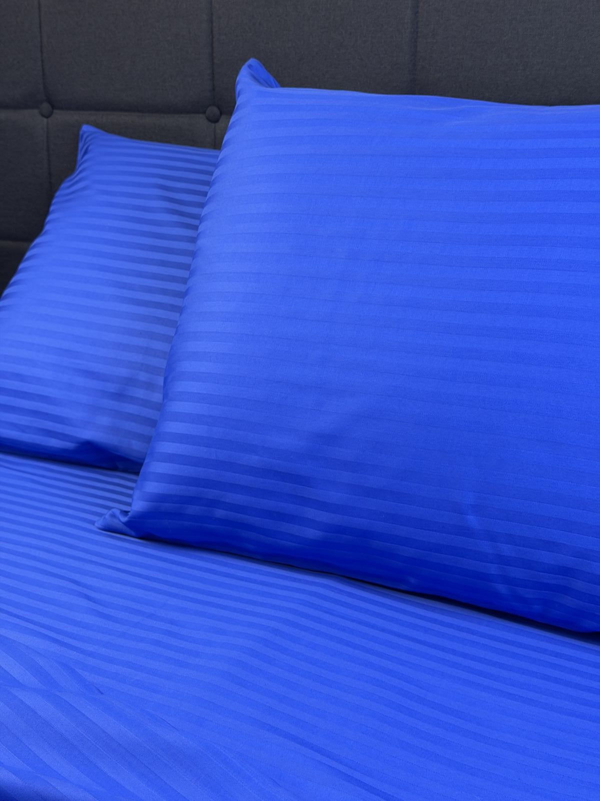 Blue sateen duvet cover and pillowcases styled in modern bedroom