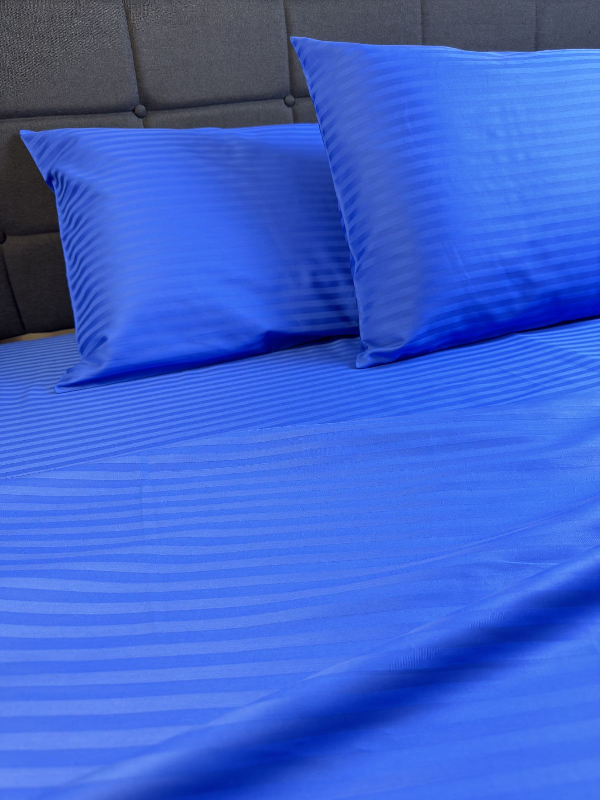 Detail of blue sateen pillowcase showing soft sheen and stitching