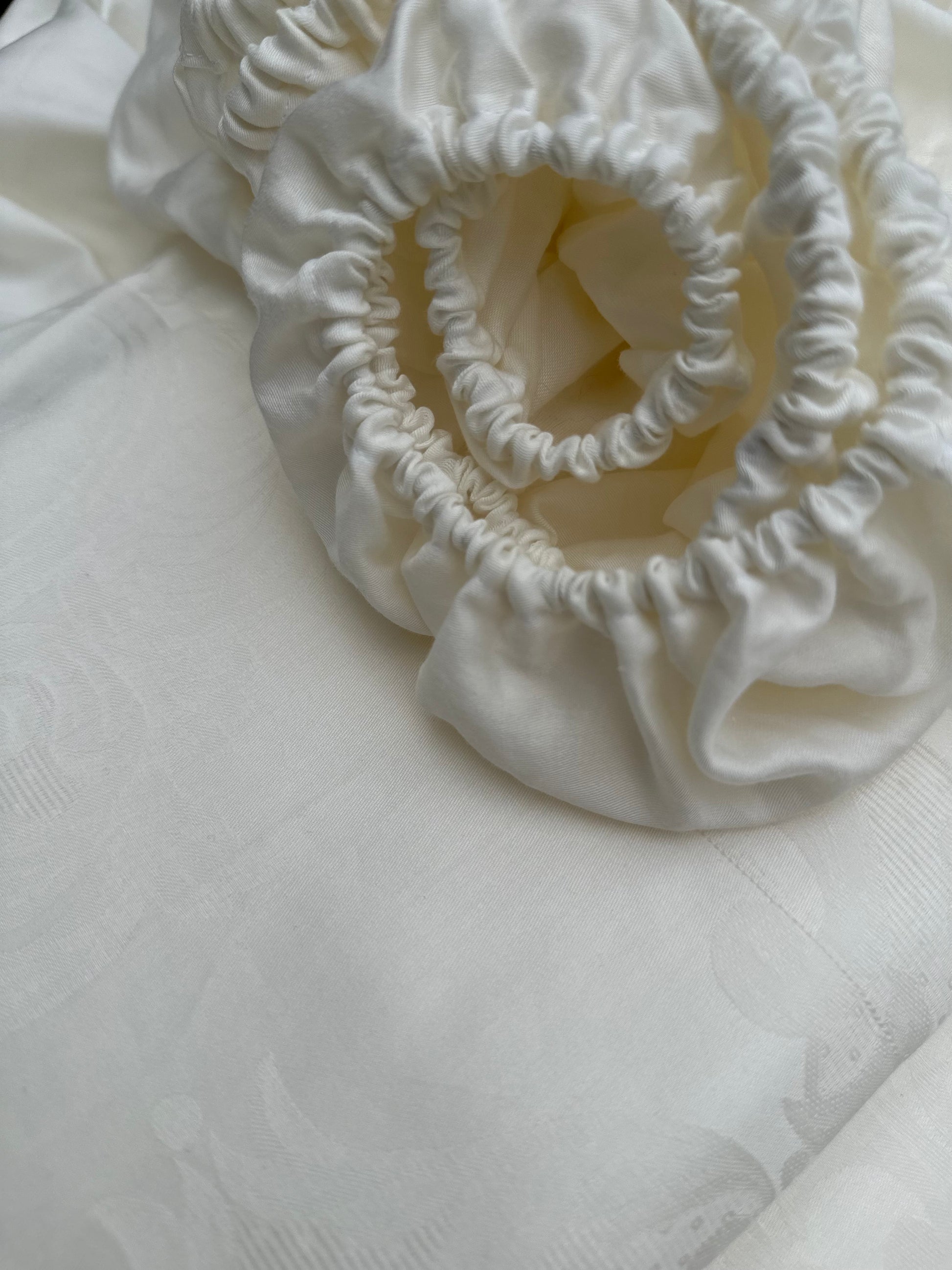 Folded organic sateen fitted sheet in soft beige color