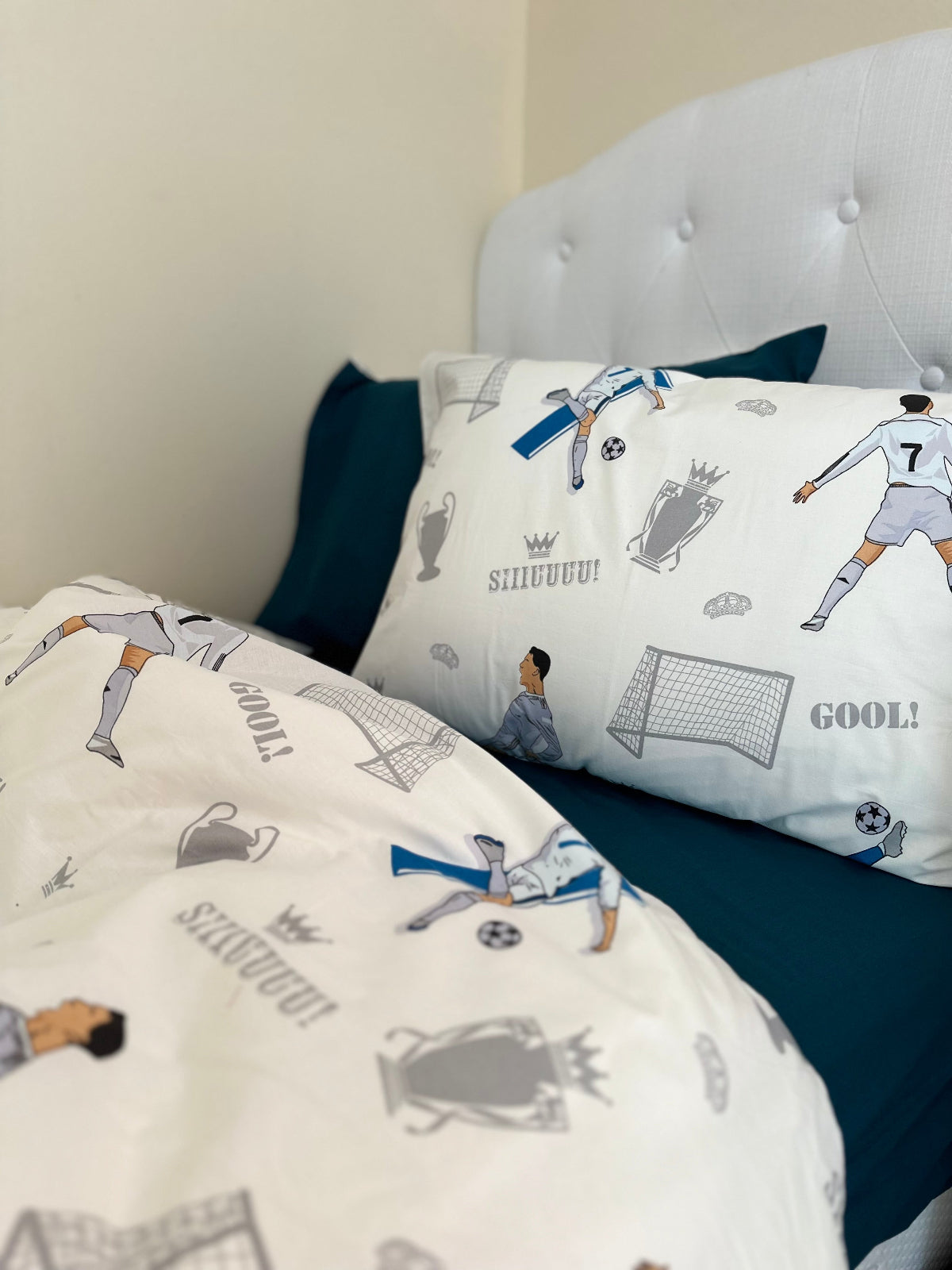 Children’s soccer bedding pillow with cartoon football player and bright blue backdrop