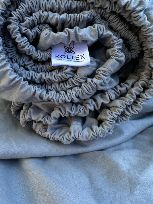 Rolled grey fitted sheet made from 100% natural Ranforse cotton with elastic edge – ideal for modern bedrooms in the U.S., Canada, Australia, and Europe.